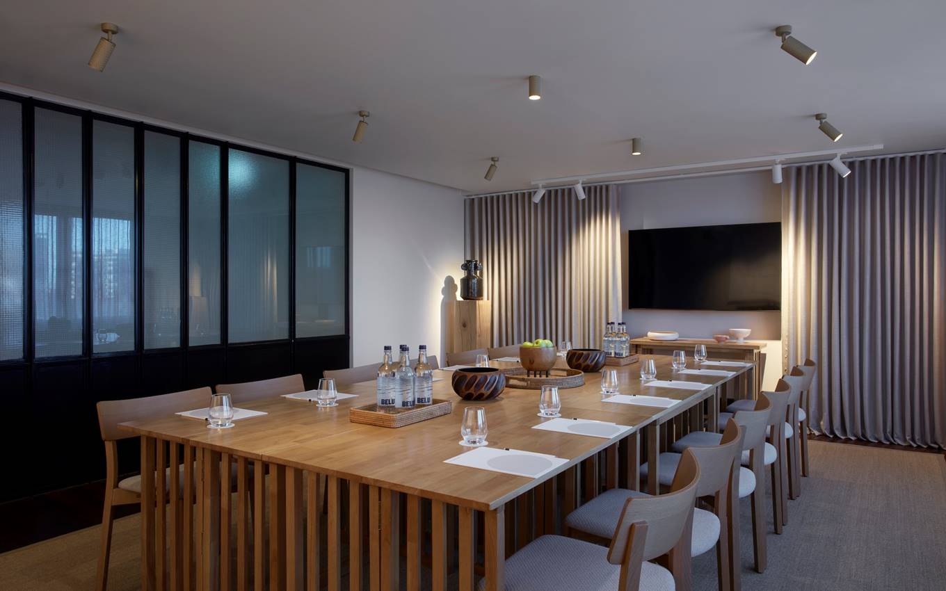 A conference room featuring wooden tables and chairs, designed for meetings and collaborative discussions.