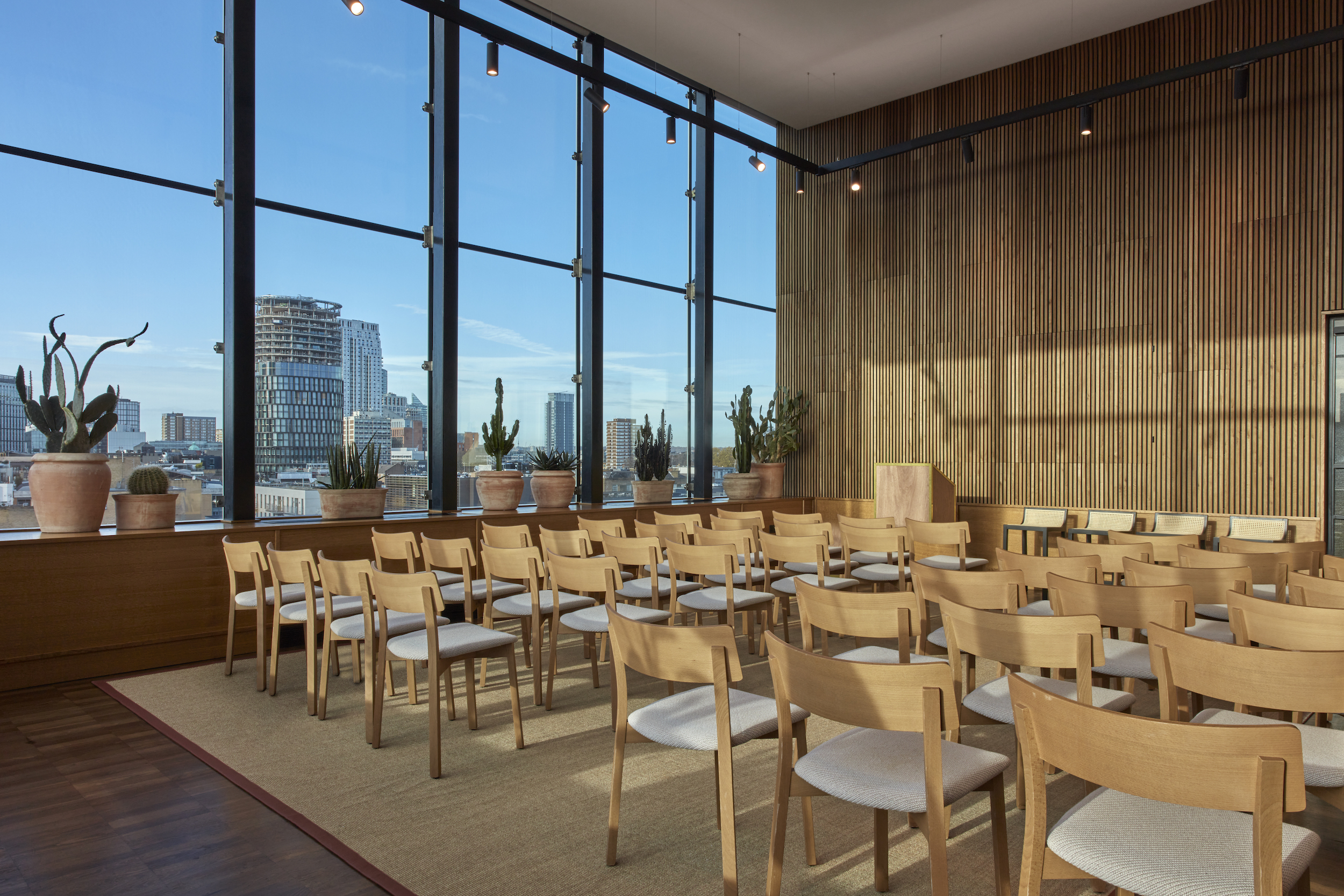 A spacious dining room featuring large windows that offer a panoramic view of the city skyline.