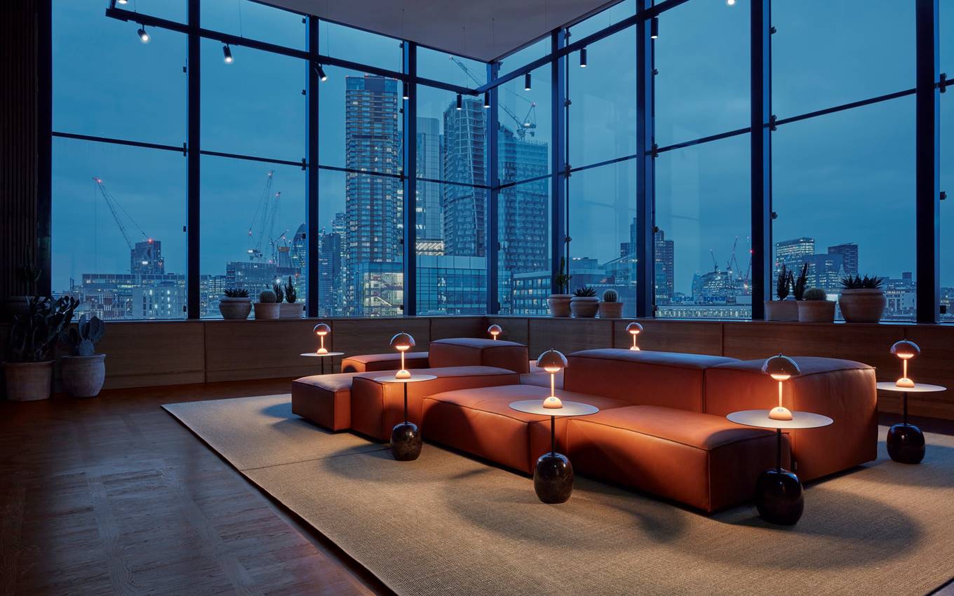 A cosy reception area featuring a stunning view of the London city skyline illuminated at night.