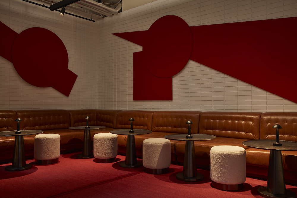 A bar featuring red and white walls, complemented by stylish stools for a vibrant and inviting atmosphere.