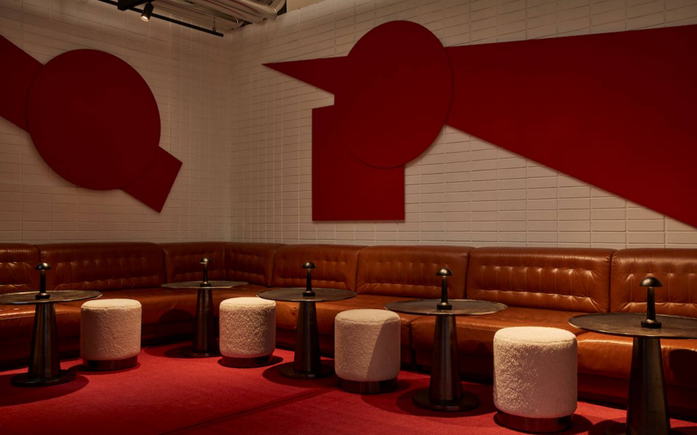 A bar featuring red and white walls, complemented by stylish stools for a vibrant and inviting atmosphere.
