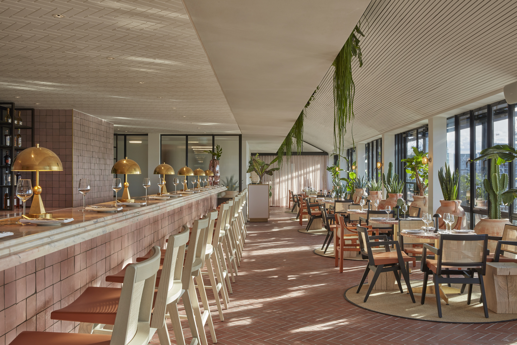 A hotel bar elegantly surrounded by lush greenery, creating a serene and inviting atmosphere for guests.