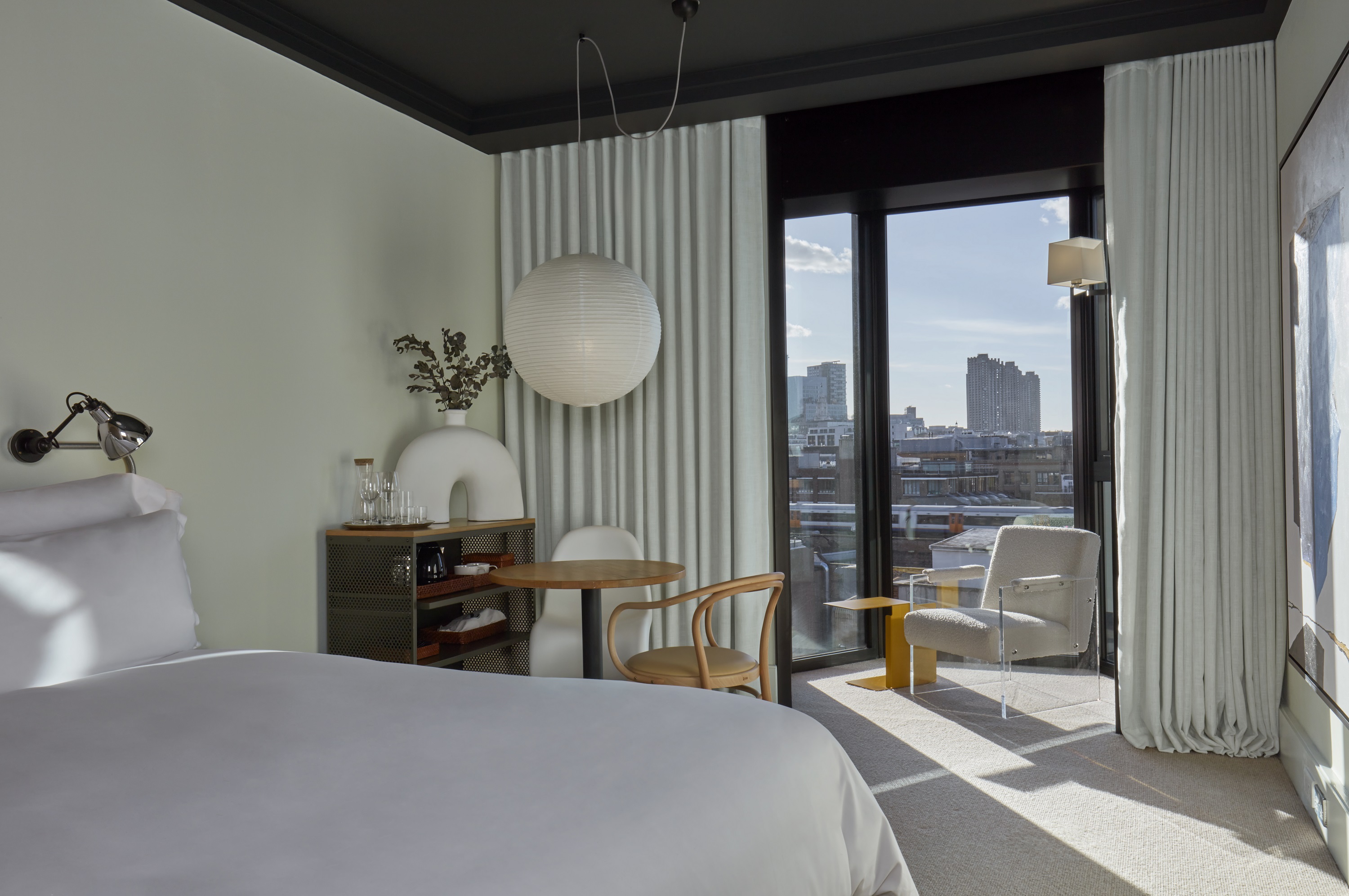 A welcoming bedroom featuring a bed and a stunning view of the city skyline through large windows.