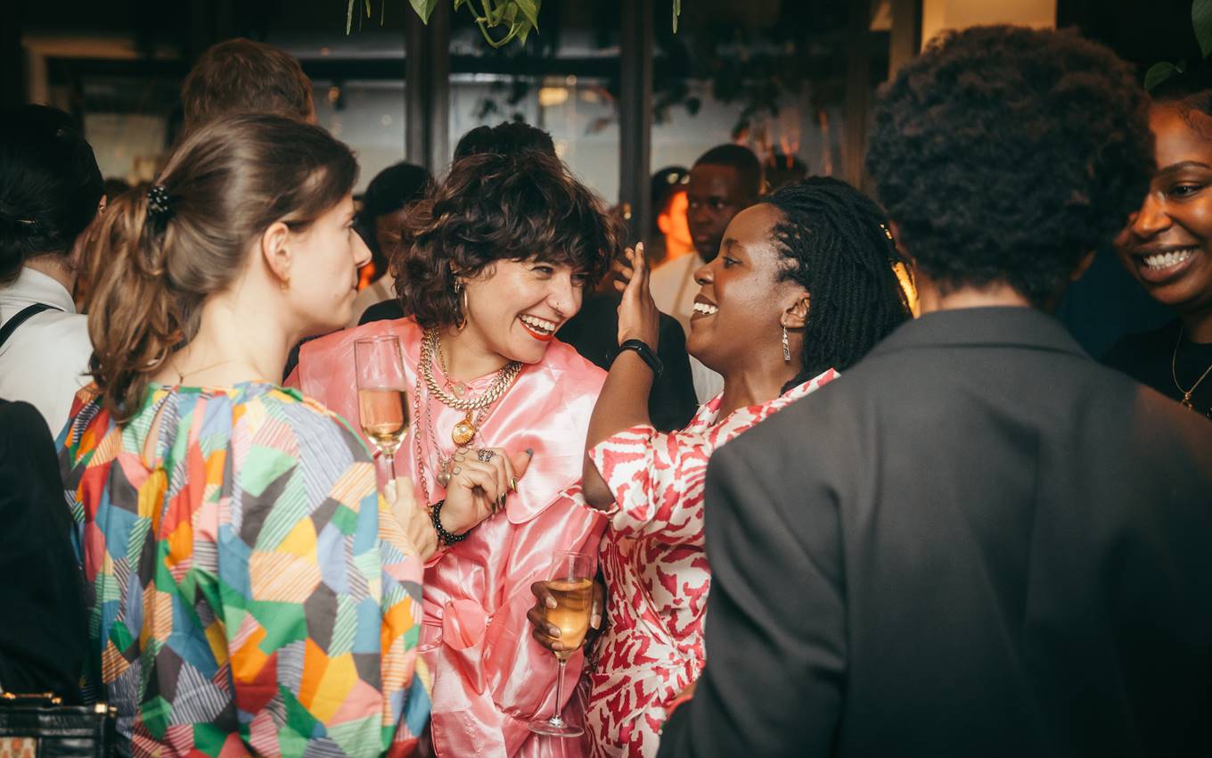 A group of women engaged in lively conversation at a festive gathering, enjoying each other's company at a party.