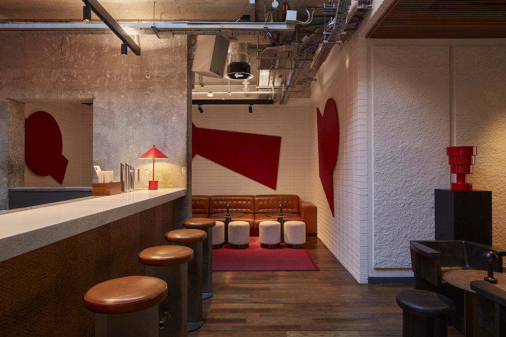 A bar featuring red and white walls, complemented by stylish stools for a vibrant and inviting atmosphere.