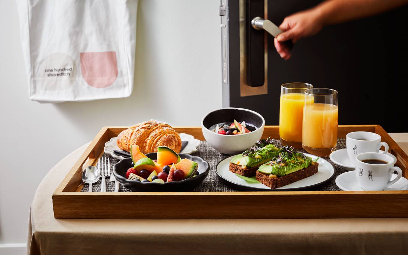 A tray filled with a variety of breakfast items, including eggs, toast, and fruit, set for a morning meal.