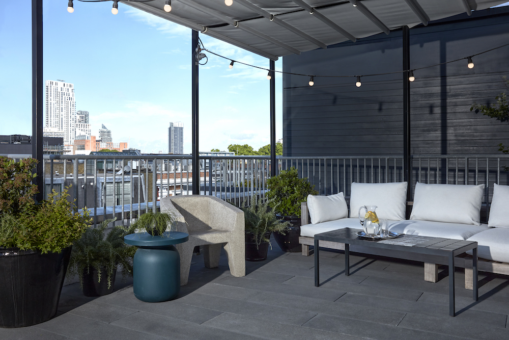 A balcony featuring white furniture, offering a scenic view of the city skyline.