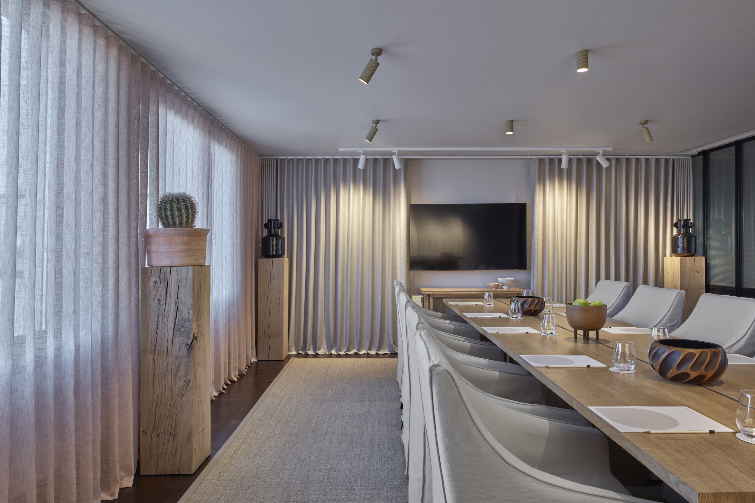 A conference room featuring a long table surrounded by chairs, designed for meetings and discussions.