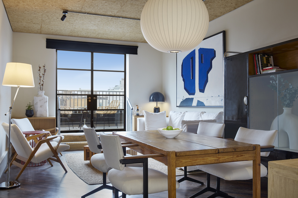 A modern living room featuring a table surrounded by chairs, creating an inviting space for gatherings and relaxation.